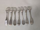 six forks and a spoon are lined up on a table