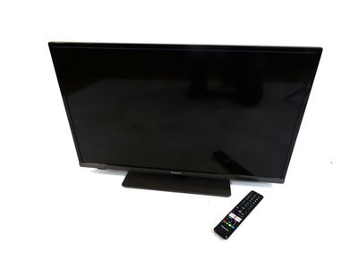 La télévision à écran plat est posée sur un meuble et est équipée d'une télécommande.