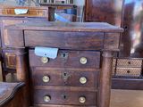 une commode en bois et une chaise dans une pièce