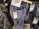 many pairs of pants hanging on a rack in a store