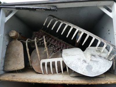 un tas d'outils de jardinage dans une boîte ouverte