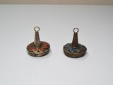 deux petites clochettes en métal posées sur une table blanche