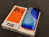 Un iPhone orange est posé dans une boîte sur une table