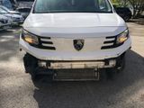 the front end of a white pickup truck parked in a parking lot