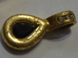 a gold plated brooch with a black stone in it