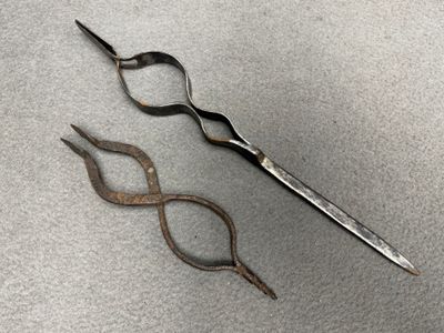 Deux porte rebus en fer forgé. L.