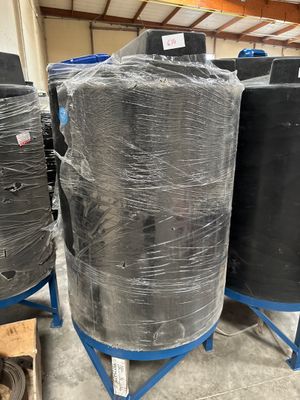 several large black barrels are wrapped in plastic and stacked on top of each other