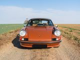 a car that is parked on the side of a dirt road