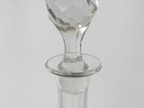 a clear glass bottle with a diamond shaped stopper on it
