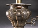 a silver vase with a handle and a faucet attached to it