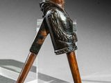une statue représentant un homme avec une canne, posée sur une table