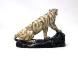 statue of a tiger on a rock on a white background