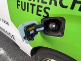 a green and white car with a fuel pump attached to it