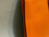an orange handbag hanging on a wall