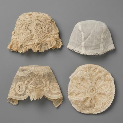 un lot de quatre chapeaux munis de lacets, posés sur une surface grise