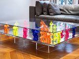 une table basse en verre sur laquelle sont disposés de nombreux animaux en plastique colorés