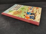 an old children ' s book is sitting on a black surface