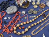 many different types of jewelry on a blue surface