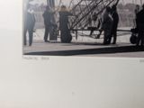 a black and white photo of a group of people standing around an airplane