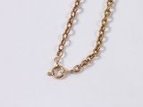 a close up of a gold chain on a white surface
