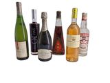 plusieurs bouteilles de vin sont alignées sur une surface blanche