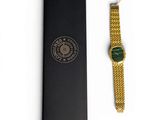a close up of a watch in a black box on a white surface