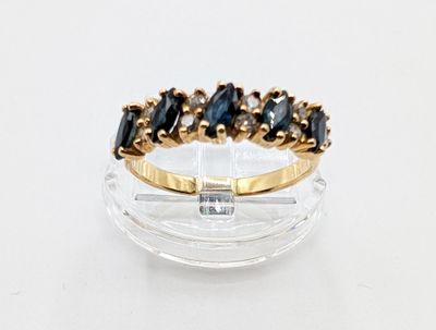 an image of a gold ring with black and white stones on it
