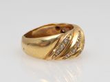 a close up of a gold ring with diamonds on a white surface