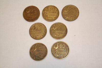 six different coins are arranged on a white surface