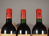 four bottles of wine are lined up in a row on a table