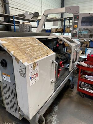 une photo d'une machine dans une usine, avec une boîte en carton à l'arrière