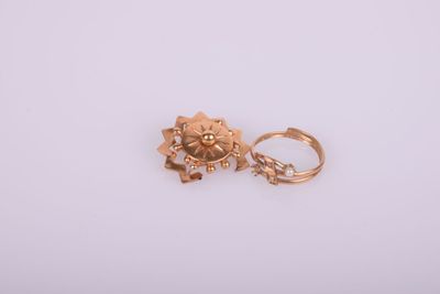 gros plan d'une paire de boucles d'oreilles en or sur une surface blanche