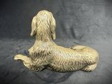 golden dachshund dog figurine on a black background