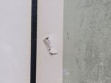 a picture of a corner of a bathroom with a hole in the wall