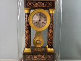 une petite horloge sous un dôme de verre sur une table