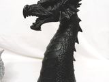 a statue of a black dragon on a white background