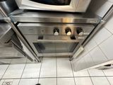 un micro-ondes posé sur une cuisinière dans une cuisine