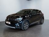 Une voiture noire est garée dans une grande pièce aux murs blancs.