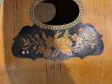 a wooden guitar with a floral design on it
