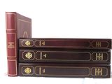three books are stacked on top of each other on a white surface
