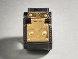 an image of a black and gold watch on a white surface