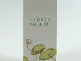 une photo d'un flacon de parfum posé sur une table blanche