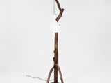 a wooden floor lamp with a white shade on top of it
