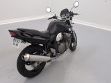 a black motorcycle parked in a room with a white wall