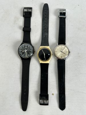 three different watches sitting on top of a white surface