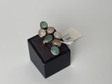 un gros plan d'une bague posée sur une boîte noire, avec une étiquette de prix