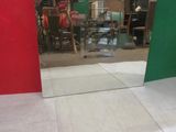 a mirror in the middle of a room with a red and green wall