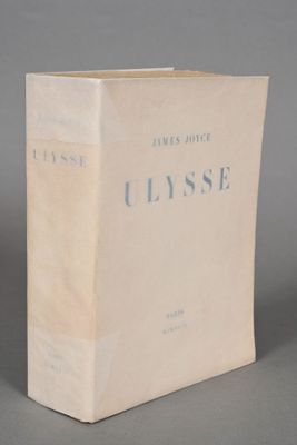 an old book sitting on top of a table on a gray surface