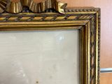 a picture of a gold framed mirror with a clock on it