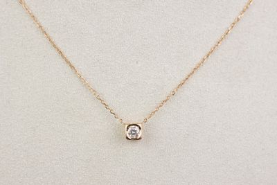 un collier en or orné d'un diamant blanc, monté sur une chaîne en or